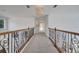 Second floor hallway featuring carpeted floors, decorative railings, and modern light fixture at 13130 Meergate Cir, Orlando, FL 32837