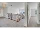 Upstairs hallway featuring a decorative railing, carpeted floor, and natural light from the window at 13130 Meergate Cir, Orlando, FL 32837