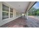 A long, covered outdoor patio offers brick flooring, with a view of the pool and backyard at 13130 Meergate Cir, Orlando, FL 32837