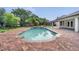 Inviting pool area featuring a brick patio and lush tropical landscaping, perfect for relaxation and outdoor enjoyment at 13130 Meergate Cir, Orlando, FL 32837