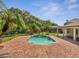 Inviting pool area featuring a brick patio and lush tropical landscaping, perfect for relaxation and outdoor enjoyment at 13130 Meergate Cir, Orlando, FL 32837