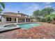 A luxurious backyard showcasing a sparkling pool, a relaxing hot tub, and a spacious brick patio at 13130 Meergate Cir, Orlando, FL 32837