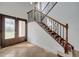 Elegant staircase with wood and wrought iron banister and glass paneled entry doors at 13130 Meergate Cir, Orlando, FL 32837