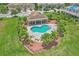 Aerial view showcasing a heart-shaped community pool with lounge chairs and lush tropical landscaping at 1628 Portofino Meadows Blvd, Orlando, FL 32824