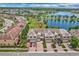 Aerial view showing a townhouse complex with brick driveways, a serene lake, and lush landscaping at 1628 Portofino Meadows Blvd, Orlando, FL 32824