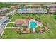 Aerial view of community pool, surrounded by lush landscaping, palm trees and sun loungers at 1628 Portofino Meadows Blvd, Orlando, FL 32824
