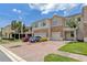 Charming townhome featuring a brick driveway, two-car garage, and stone facade at 1628 Portofino Meadows Blvd, Orlando, FL 32824