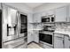 Well-equipped kitchen featuring stainless steel appliances, modern gray cabinets, and stylish tiled backsplash at 1628 Portofino Meadows Blvd, Orlando, FL 32824