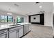 Open-concept living area featuring modern flooring, a stylish entertainment wall, and an island with a sink at 1628 Portofino Meadows Blvd, Orlando, FL 32824