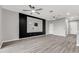 Open living room featuring hardwood floors and a modern entertainment center at 1628 Portofino Meadows Blvd, Orlando, FL 32824