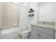 Bright bathroom featuring a tub/shower combo and granite vanity with shelving for décor at 172 Roseville Dr, Haines City, FL 33844