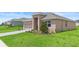 Charming single-story home featuring a brick driveway, lush lawn and welcoming covered entrance at 172 Roseville Dr, Haines City, FL 33844