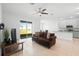 Open-concept living room adjacent to the kitchen, featuring tile flooring and sliding glass doors at 172 Roseville Dr, Haines City, FL 33844