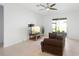Bright living room with a ceiling fan, sliding glass doors, and a comfortable brown sofa at 172 Roseville Dr, Haines City, FL 33844
