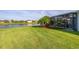 Sprawling backyard with lush lawn, mature landscaping, and serene water views at 1760 Boat Launch Rd, Kissimmee, FL 34746