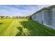 Expansive backyard with lush lawn, pond view, and the side of the house at 1760 Boat Launch Rd, Kissimmee, FL 34746