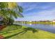 Expansive backyard with vibrant green lawn and a tranquil lake backdrop, enhanced by swaying palm trees at 1760 Boat Launch Rd, Kissimmee, FL 34746