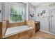 Inviting bathroom showcases a soaking tub with tiled surround, a window, and vanity at 1760 Boat Launch Rd, Kissimmee, FL 34746