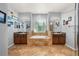 Spacious bathroom featuring double vanities, tiled floors, and a soaking tub under a window at 1760 Boat Launch Rd, Kissimmee, FL 34746