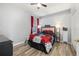 Bedroom features gray walls, hardwood floors, ceiling fan, and a bed with a floral print comforter at 1760 Boat Launch Rd, Kissimmee, FL 34746