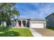 Charming single-story home featuring a red front door, well-manicured lawn, and a two-car garage at 1760 Boat Launch Rd, Kissimmee, FL 34746