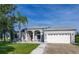 Charming single-story home with a well-manicured lawn, palm tree, and a two-car garage at 1760 Boat Launch Rd, Kissimmee, FL 34746