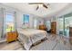 Bright main bedroom featuring wood floors, tray ceiling, and large windows with scenic outdoor views at 1760 Boat Launch Rd, Kissimmee, FL 34746