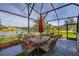 Screened patio dining with colorful decor overlooking a beautiful lake view at 1760 Boat Launch Rd, Kissimmee, FL 34746