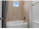 Bathroom with tan tiled walls, a shower, and a bathtub combination with gold fixtures and light bright colors at 1801 Coastal Ct, Celebration, FL 34747