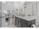Bathroom featuring a dual sink vanity with gray cabinets, gold hardware, and light bright colors at 1801 Coastal Ct, Celebration, FL 34747