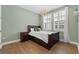 Bright bedroom featuring hardwood floors, light green walls, plantation shutters, and globe lighting at 1801 Coastal Ct, Celebration, FL 34747