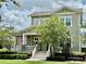 Attractive two-story house with a quaint front porch, manicured shrubs, and a beautiful American flag at 1801 Coastal Ct, Celebration, FL 34747
