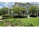 Charming two-story home features a welcoming front porch, lush landscaping, and a well-manicured lawn at 1801 Coastal Ct, Celebration, FL 34747