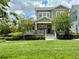 Inviting two-story home with well-kept lawn, flowering trees, and a charming front porch with American flag at 1801 Coastal Ct, Celebration, FL 34747
