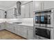 Modern kitchen boasts stainless steel appliances, gray cabinetry and gold hardware at 1801 Coastal Ct, Celebration, FL 34747