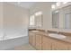 Bathroom with dual sinks, vanity, and a tiled bathtub at 231 Lewis Dr, Davenport, FL 33837