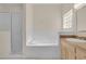 Bright bathroom featuring a bathtub, walk-in shower and vanity with sink at 231 Lewis Dr, Davenport, FL 33837