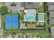 Aerial view of community amenities featuring tennis courts, pool, bocce ball, and ample parking for residents at 231 Lewis Dr, Davenport, FL 33837