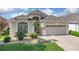 Charming home with a well-manicured lawn, lush landscaping, and a two-car garage, offering curb appeal at 231 Lewis Dr, Davenport, FL 33837