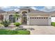 Lovely single-story home featuring a two-car garage, manicured lawn and a palm tree at 231 Lewis Dr, Davenport, FL 33837