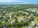 Aerial shot of a picturesque neighborhood showcases its serene location and lush trees against the backdrop of a tranquil lake at 2376 Nightingale Ln, Kissimmee, FL 34746