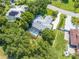 An aerial view of a home with a screen enclosed pool and spa surrounded by mature trees and lush landscaping at 2376 Nightingale Ln, Kissimmee, FL 34746