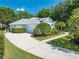 Spacious driveway leading to a well-maintained single-story home with lush greenery and a two-car garage at 2376 Nightingale Ln, Kissimmee, FL 34746