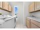 Well-lit laundry room equipped with modern washer, dryer, and ample cabinet space at 2376 Nightingale Ln, Kissimmee, FL 34746