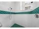 White tiled walk-in shower with a decorative, green tile accent stripe at 2376 Nightingale Ln, Kissimmee, FL 34746