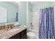 Charming bathroom featuring a granite countertop, tub with shower, and matching sink at 2416 White Poppy Dr, Kissimmee, FL 34747