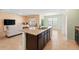 Modern kitchen with a granite-topped island and stainless steel appliances open to the living room at 2416 White Poppy Dr, Kissimmee, FL 34747