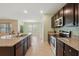 Well-lit kitchen features granite counters, stainless appliances, and open layout to the living space at 2416 White Poppy Dr, Kissimmee, FL 34747