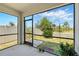 Screened-in lanai offering a relaxing outdoor space with views of the landscaped backyard and blue skies at 2416 White Poppy Dr, Kissimmee, FL 34747