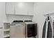 Efficient laundry room is equipped with modern front-load machines, overhead cabinets, and folding area at 2416 White Poppy Dr, Kissimmee, FL 34747